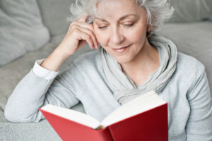 ältere, attraktive Frau genießt ein Buch